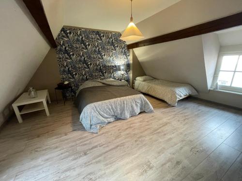 une chambre avec deux lits dans un grenier dans l'établissement Au Vieux Porche Colmar, à Colmar