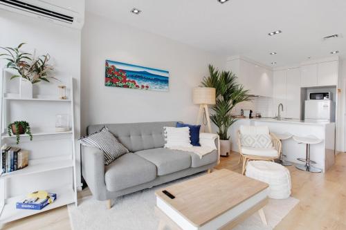 a living room with a couch and a table at Takapuna Central Stylish 2BR Carpark Aircon in Auckland