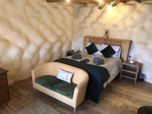 a bedroom with a large bed and a chair at Rabbits 1or 2 bedroom hobbit style hillset earthen dartmoor eco home in South Brent