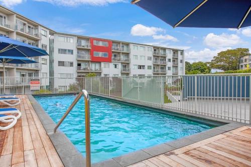 a swimming pool in front of a apartment building at Takapuna Central Stylish 2BR Carpark Aircon in Auckland