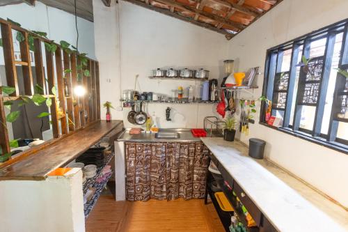 a kitchen with a counter and a sink and windows at Pipa Surf House in Pipa