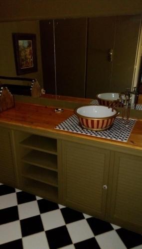 a bathroom with a counter with two sinks and a mirror at Hidden Dragon Guest Rooms in Swellendam
