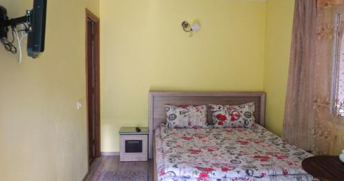 - une chambre avec un lit dans une pièce jaune dans l'établissement Casa Coralis, à Călimăneşti