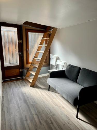 un salon avec un canapé et un escalier dans l'établissement Duplex Rue Huchette - DABNB, à Limoges