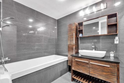 a bathroom with a tub and a sink and a bath tubermottermott at Luxurious 2 Bedroom 2 Bathroom Condo Downtown Montreal in Montréal