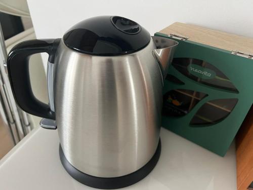 a black and silver tea kettle next to a box at Grande appartamento con Terrazza vicino a Milano e Como in Lissone