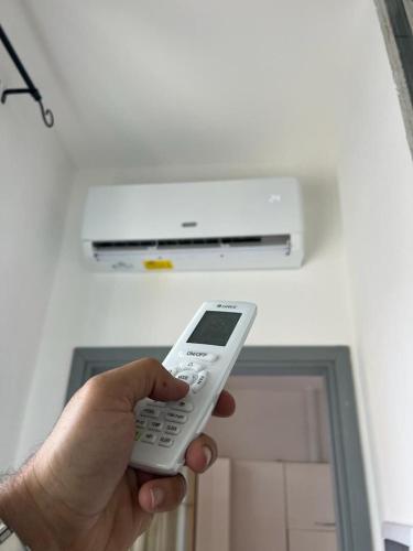 a person holding a remote control in front of a heater at Grande appartamento con Terrazza vicino a Milano e Como in Lissone