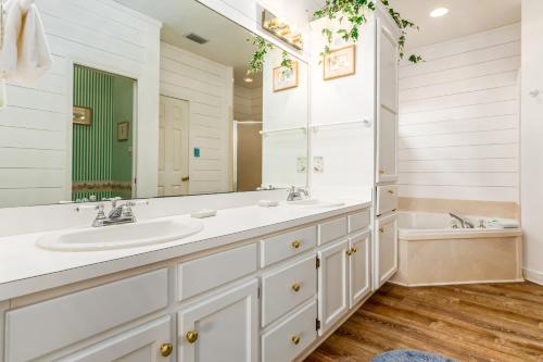 a bathroom with two sinks and a large mirror at Tan Lines in Dauphin Island