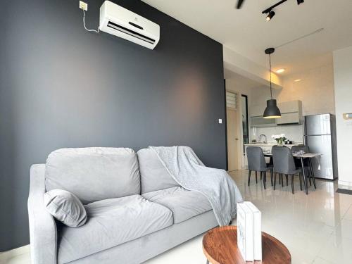 a living room with a white couch and a table at D'Summit Suite by Luxecocoo CK Kempas Setia Tropika in Kempas
