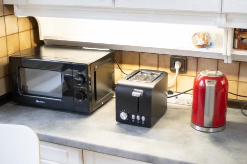 a microwave oven sitting on a counter with a toaster at Ferienhaus große Villa "Smart home" in Euskirchen