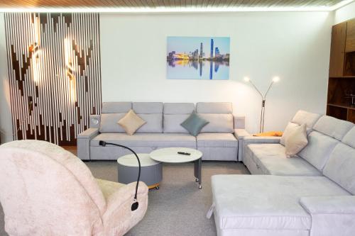 a living room with a white couch and a table at Ferienhaus große Villa "Smart home" in Euskirchen