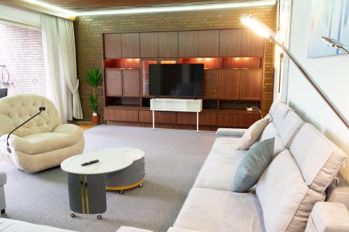 a living room with a couch and a tv at Ferienhaus große Villa "Smart home" in Euskirchen