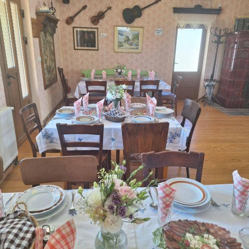 a dining room with tables and chairs with flowers on them at Pansion Sašin Salaš 40m2 in Rumenka