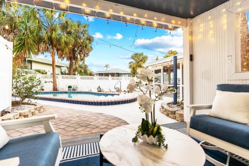 an outdoor patio with a table and a pool at Private Heated Pool - 100 Steps to Beach Access - 5-min walk to Siesta Key Village in Siesta Key