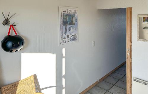 a room with a refrigerator and a helmet on the wall at 2 Bedroom Awesome Home In Glesborg in Glesborg