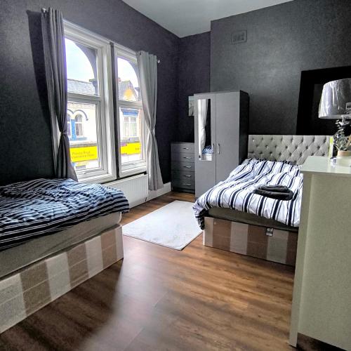 a bedroom with two beds and a large window at Modern home in heart of Middlesbrough town in Middlesbrough