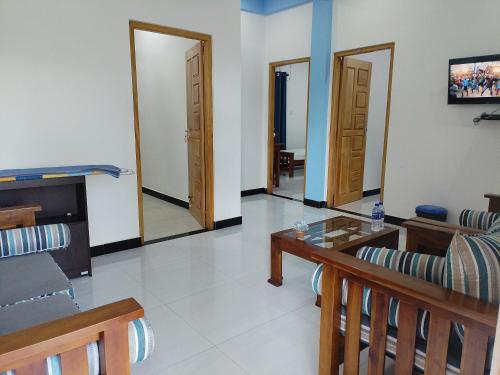 a living room with two doors and a table and chairs at Victory's Gardens in Mannar