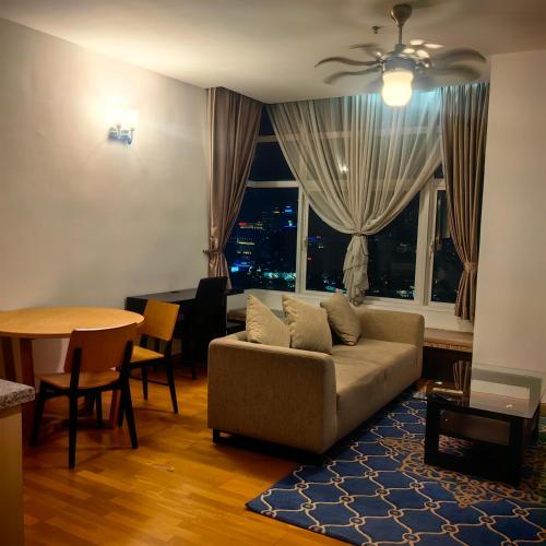 a living room with a couch and a table at KL Sentral Dua Sentral Cozy Homestay Apartments by Hollywood Homes #FreeCarPark in Kuala Lumpur