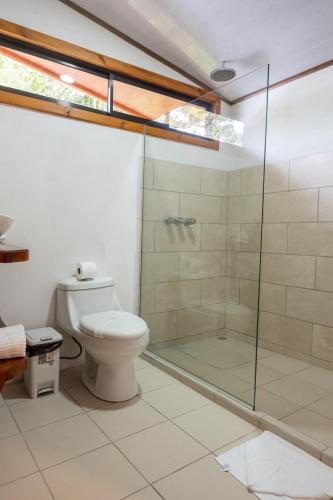 a bathroom with a toilet and a glass shower at Tierra Buena Countryside Hotel in Monteverde Costa Rica