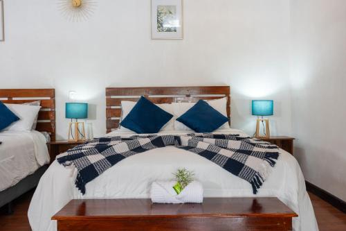a bedroom with a large bed with blue pillows at Tierra Buena Countryside Hotel in Monteverde Costa Rica