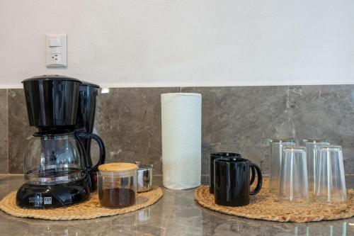 a kitchen counter with a coffee maker and cups at Tierra Buena Countryside Hotel in Monteverde Costa Rica