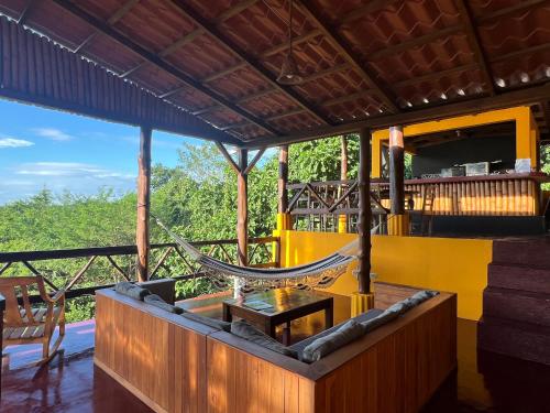 a room with a hammock and a table and chairs at Buena Onda Backpackers in San Juan del Sur