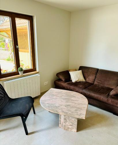 un salon avec un canapé et une table basse dans l'établissement Très joli logement, à Anould