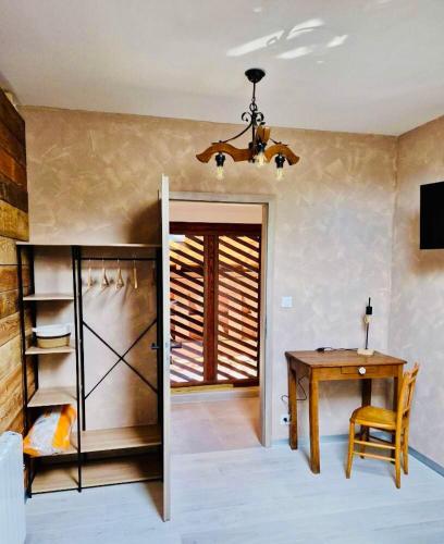 une salle à manger avec une table et un lustre dans l'établissement Très joli logement, à Anould