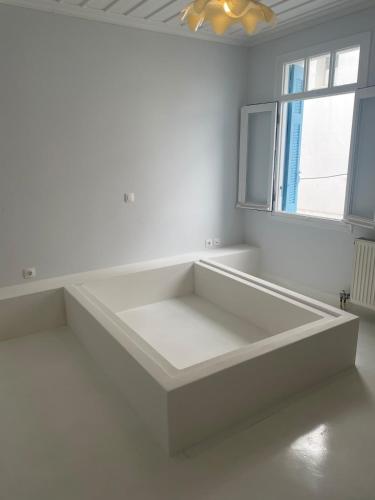 a white room with a large white couch in front of a window at Relax with a view in Batsi