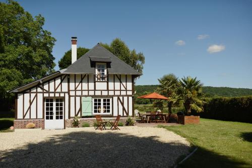 Maison blanche et noire avec une table et des chaises dans l'établissement Chaleureux cottage normand en zone Natura 2000, à Freneuse-sur-Risle