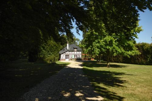 une maison au milieu d'un champ avec des arbres dans l'établissement Chaleureux cottage normand en zone Natura 2000, à Freneuse-sur-Risle