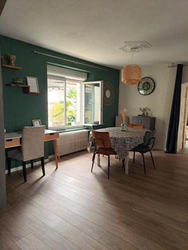 un salon avec une table et des chaises de salle à manger dans l'établissement Jolie maison de ville avec un extérieur au calme - Les Dragons de la Chamoiserie NIORT, à Niort