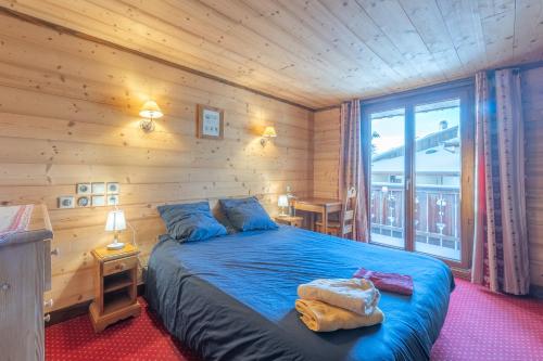 une chambre avec un lit bleu dans une pièce en bois dans l'établissement Alpe Two - Sea and Mountain Pleasure 12P- Pieds des Pistes- Centre - Jacuzzi - Sauna - 5 Chambres - 5 Salle de bains, à L'Alpe-d'Huez