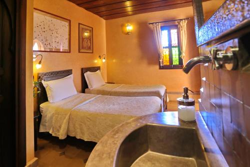 Cette chambre comprend 2 lits et un lavabo. dans l'établissement Riad Marrakiss, à Marrakech