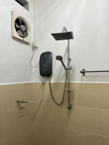 a shower in a bathroom with a blow dryer at M Guest House2 in Muar