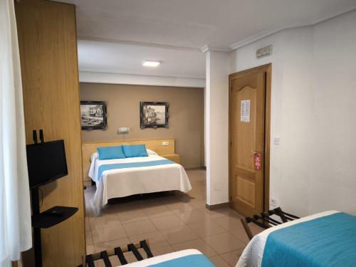 a hotel room with two beds and a television at Hostería VISTAPARK in El Astillero