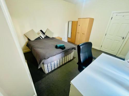 a small room with a bed and a black chair at 154 double room in Nottingham