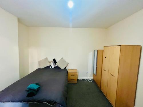 a bedroom with a bed and a wooden cabinet at 154 double room in Nottingham