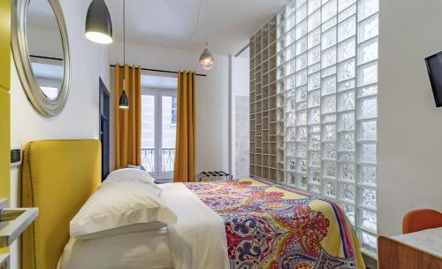 una camera da letto con un letto e una parete con uno specchio di DAB Guest House a Roma