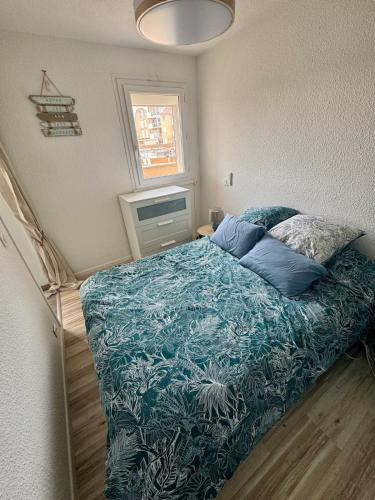 une chambre avec un lit avec une couette bleue dans l'établissement La Casa Marina - Cozy apartment Frontignan Plage, à Frontignan