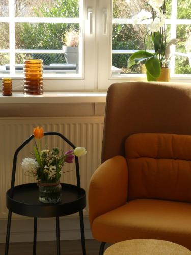 ein Wohnzimmer mit einem Stuhl und einem Tisch mit Blumen in der Unterkunft Landhaus SoonZauber in Münchwald