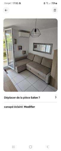 un salon avec un canapé et une fenêtre dans l'établissement cocon la faviere, à Bormes-les-Mimosas