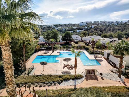 Una vista aérea de un resort con piscina y palmeras. en Las Colinas Golf Residences, en San Miguel de Salinas