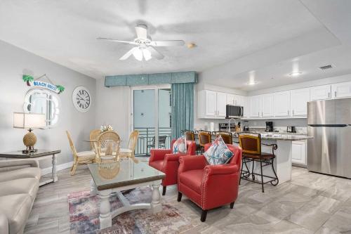 a living room with red chairs and a kitchen at Luxury 8th Floor 2 BR Condo Direct Oceanfront Wyndham Ocean Walk Resort Daytona Beach | 801 in Daytona Beach