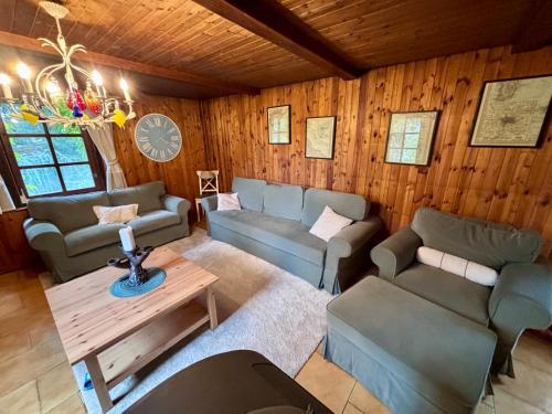 a living room with couches and a table at Chata u rybníka Machčák in Třebušín