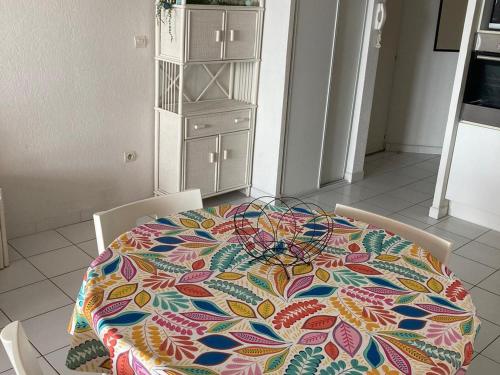 une table avec un tissu de table coloré en haut dans l'établissement Superbe T3 44m² avec loggia et piscine, parking inclus, face à la mer, 2⭐️ - FR-1-472A-229, à Sète