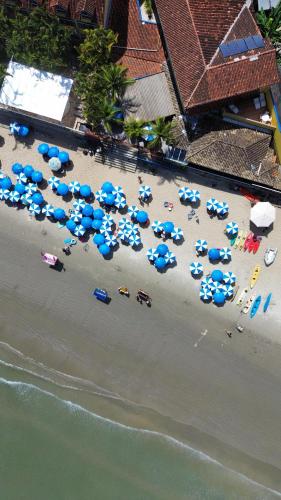 an aerial view of a beach with umbrellas and cars at Kaliman Pousada in Ubatuba