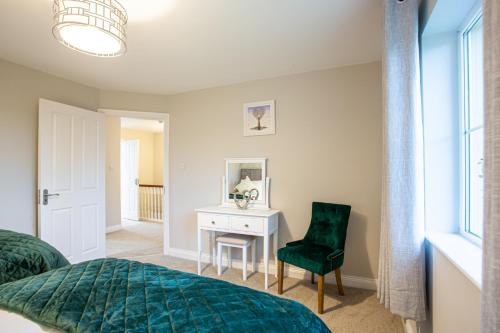 a bedroom with a bed and a desk and a chair at No 20 Killarney Holiday Village in Killarney