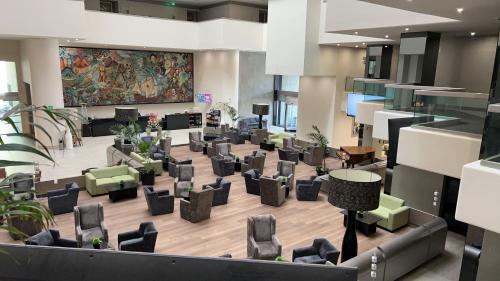 a lobby with chairs and a large painting on the wall at Crowne Plaza Hotel Mexico City North-Tlalnepantla by IHG in Mexico City