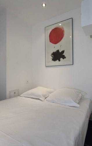 - une chambre dotée d'un lit blanc avec une photo sur le mur dans l'établissement Studio ELLE et LUI Port Nature PN830 - Luxe - 2 personnes, au Cap d'Agde